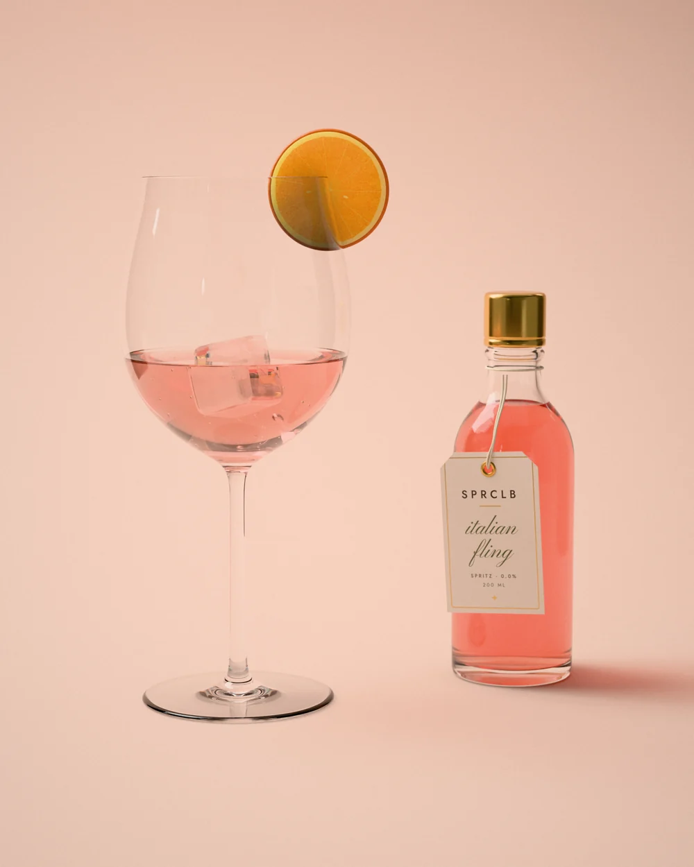 Italian Fling: a coral-pink spritz over ice in a balloon glass with an orange wheel on the rim, beside a clear SPRCLB bottle with a gold cap and its Italian Fling tag